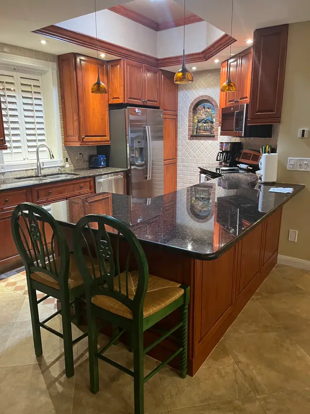 Wood kitchen with a granite island and green bar stools